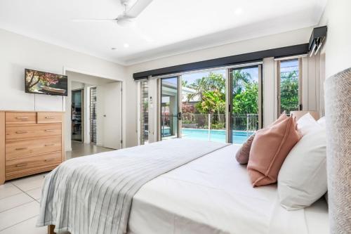 ポートダグラスにあるVilla Jacana at Port Douglasの大きなベッドと大きな窓のある寝室