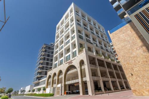 a tall white building with an arch in front at Mood Living 45 in Dubai