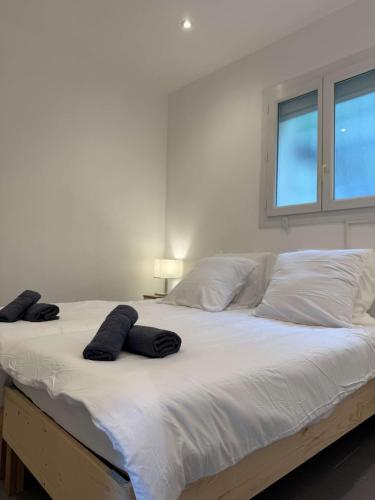 - un grand lit blanc avec 2 oreillers noirs dans l'établissement RARE - New apartment in the heart of Cannes, à Cannes