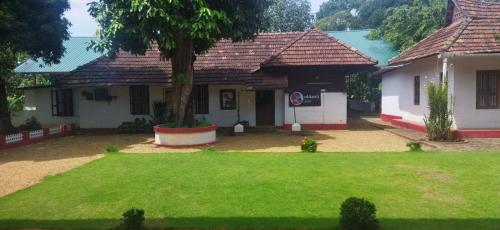 a house with a green lawn in front of it at Akkara Homestay in Kottayam