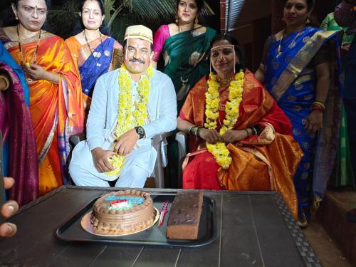 a group of people standing around a man cutting a cake at West Coast Gokarna in Gokarna