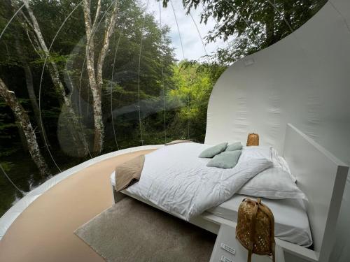 a bed in a room with a large window at Cabanes de la Romaningue in Pompignac