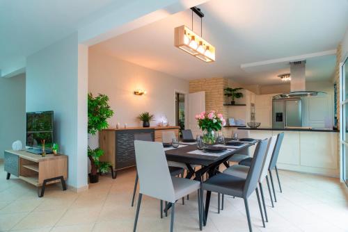 une cuisine et une salle à manger avec une table et des chaises dans l'établissement L'Escapade des Embruns - proche plage, à Damgan