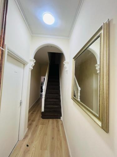a hallway with a staircase and a mirror on the wall at Double Room Near Railway station & Football Ground 88 in Nottingham