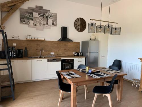 - une cuisine avec une table et des chaises en bois dans l'établissement Le mirondel, à Raillicourt