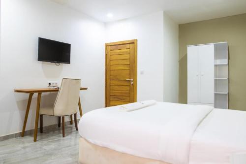 a bedroom with a bed and a desk and a television at Aylane Hotel in Nampula