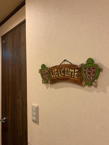 a welcome sign on a wall next to a door at ALOHADAYS Nishijin Guesthouse in Kyoto