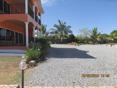 a building with a gravel driveway next to a building at Jamaica Inn Guest House in Bortianor