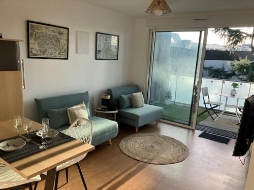 un salon avec un canapé et une table dans l'établissement T2 Cosy Terrasse 13m2 Parking gratuit, à Bordeaux