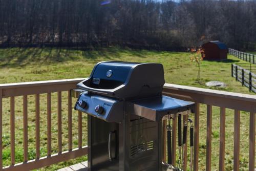 a grill sitting on top of a wooden railing at Couples Retreat - The HayLoft- Rustic Escape For 2 in Oakland