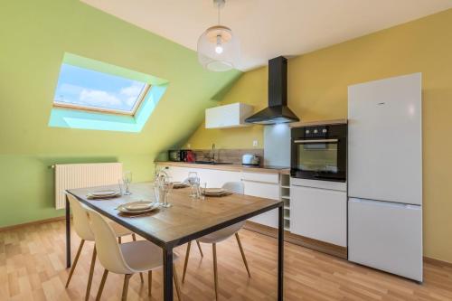une cuisine avec une table en bois et des appareils électroménagers blancs dans l'établissement Appartement 2 chambres proche métro & tram, à Roubaix