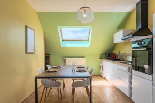 une salle à manger avec une table et des chaises dans une cuisine dans l'établissement Appartement 2 chambres proche métro & tram, à Roubaix