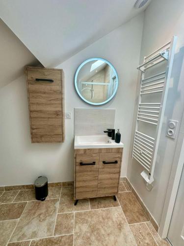 une salle de bain avec un lavabo et un miroir dans l'établissement La Fosse rue des champs, à Tigy