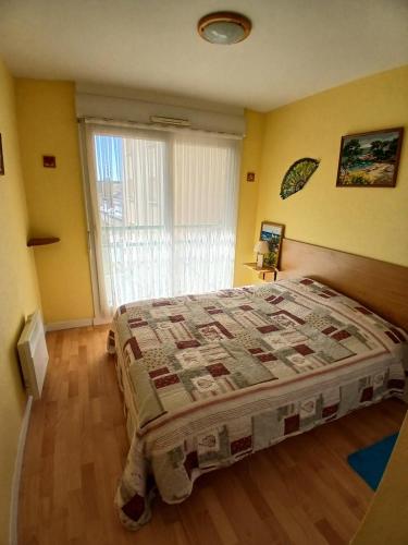 ein Schlafzimmer mit einem Bett und einem großen Fenster in der Unterkunft Appar bray-dunes in Bray-Dunes