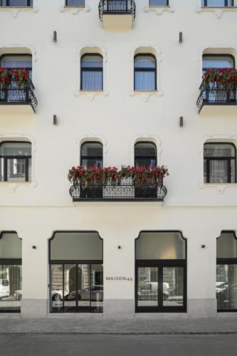 a white building with windows and flower boxes at Maison 45 - Luxury Boutique Hotel in Budapest