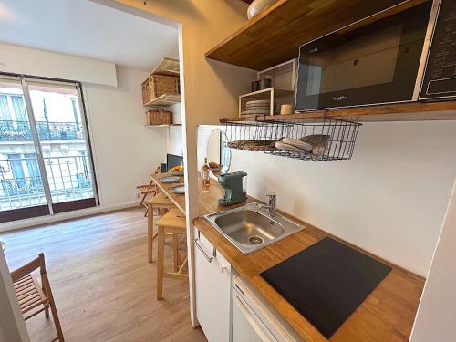 une cuisine avec un évier et un plan de travail dans l'établissement L'appartement Larminat, à Paris