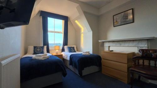 a hotel room with two beds and a window at Royal Temple Yacht Club in Ramsgate