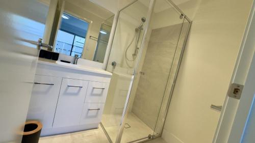 a glass shower in a bathroom with a window at Brand-New Unit in a Modern Complex – Your Perfect Getaway! in Williamstown