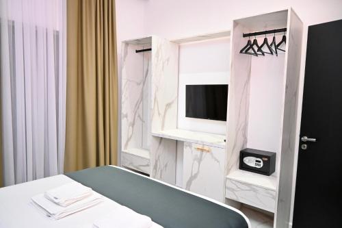 a hotel room with a bed and a television at Vila La Familia in Ksamil