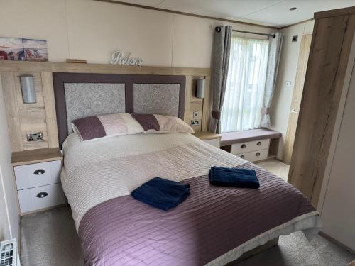 a bedroom with a large bed with two blue towels on it at Luxury 2 Bedroom van linen included Pets go Free in Hunstanton