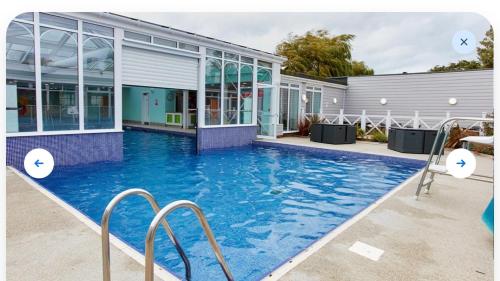 a swimming pool in front of a building at Luxury 2 Bedroom van linen included Pets go Free in Hunstanton