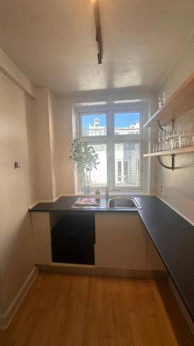 a kitchen with a sink and a window at Løvstræde apartments from 1 to 6 in Copenhagen