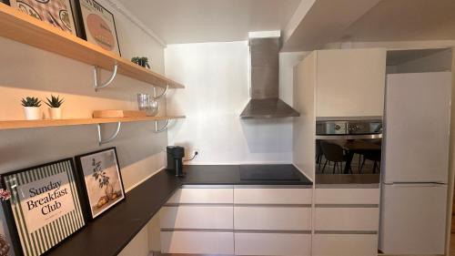 a kitchen with a white refrigerator and a table at Løvstræde apartments from 1 to 6 in Copenhagen