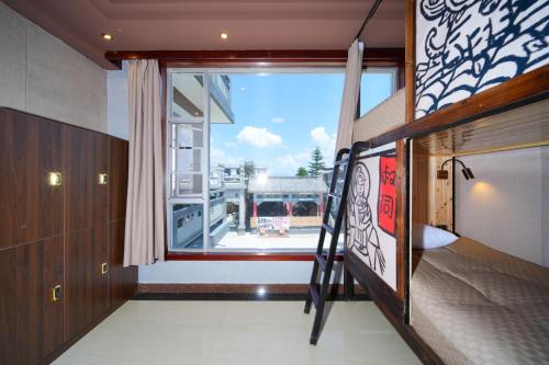 大理古镇Da Bing's House Youth Park Dali Store的一间卧室设有双层床和大窗户