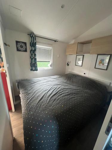 - une chambre avec un lit noir et une fenêtre dans l'établissement 538 mobile home grand confort, à La Teste-de-Buch