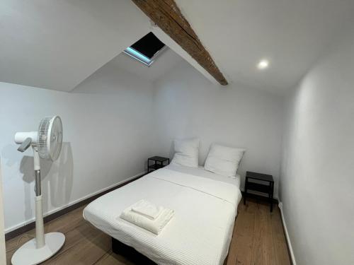 - une chambre avec un lit blanc et un ventilateur dans l'établissement Spacieux appartement T4 / 70 m2 8 personnes, à Aix-en-Provence
