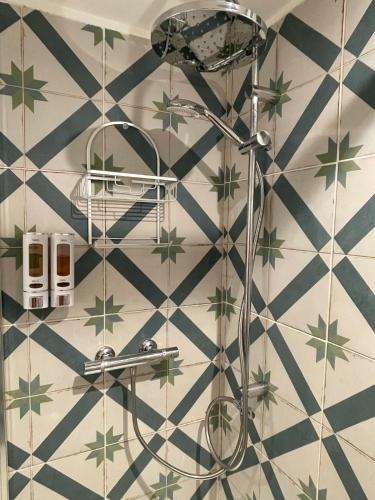 La salle de bains est pourvue d'une douche avec des étoiles vertes sur le mur. dans l'établissement Spacieux appartement T4 / 70 m2 8 personnes, à Aix-en-Provence