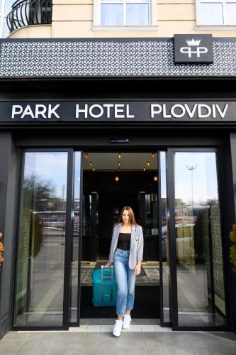 a woman is standing outside of a park hotel playbook at Park Hotel Plovdiv in Plovdiv