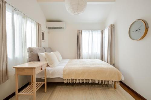 a bedroom with a bed and a clock on the wall at 優楽苑 113t in Tokyo
