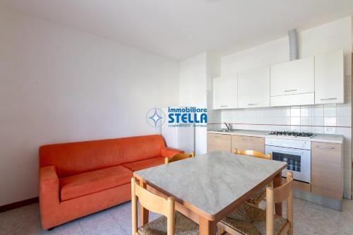 a living room with an orange couch and a table at Residence Adriatica in Lido di Jesolo