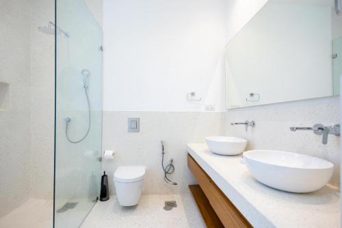 a bathroom with two sinks and a glass shower at Amkia Villas Diani in Diani Beach