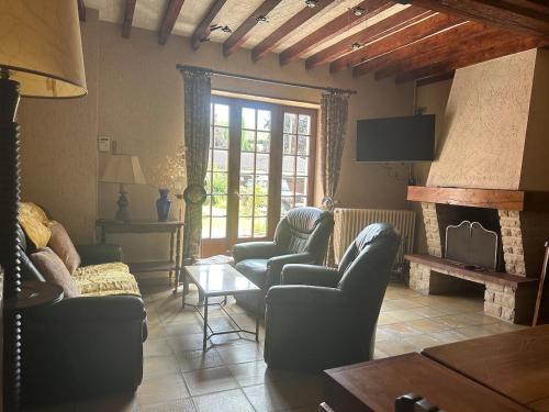 un salon avec des canapés et une cheminée dans l'établissement Maison du vignoble à 5 minutes de Chablis, à Beine