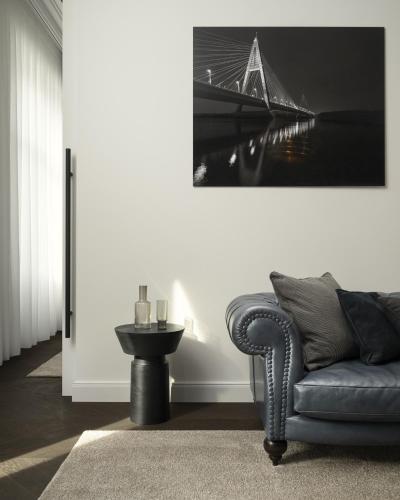 a living room with a couch and a bridge painting on the wall at Maison 45 - Luxury Boutique Hotel in Budapest