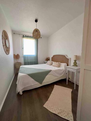 une chambre avec un grand lit et une fenêtre dans l'établissement Évasion Méditerranéenne, à Gruissan