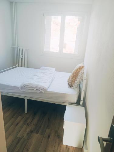 un petit lit dans une chambre avec une fenêtre dans l'établissement Chambre lumineuse et cosy proche des transports et commerces, à Besançon