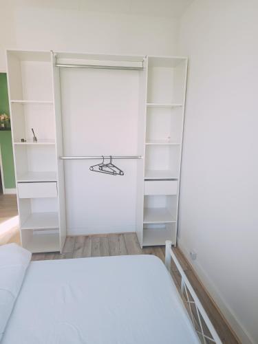 - une chambre avec des étagères blanches et un lit dans l'établissement Chambre lumineuse et cosy proche des transports et commerces, à Besançon