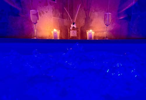 - une table avec 2 bougies et 2 bouteilles de vin dans l'établissement Maison de vacances à la ferme - Déconnexion en Normandie - Balnéo, à Annouville-Vilmesnil