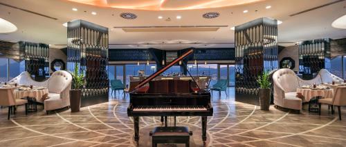 a grand piano in a dining room with tables at Hilton Bursa Convention Center & Spa in Bursa