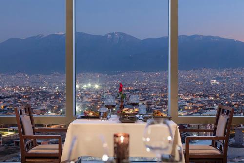 a table with wine glasses and a view of a city at Hilton Bursa Convention Center & Spa in Bursa