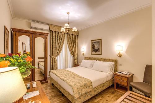 um quarto de hotel com uma cama e uma cadeira em Hotel Cortina em Roma