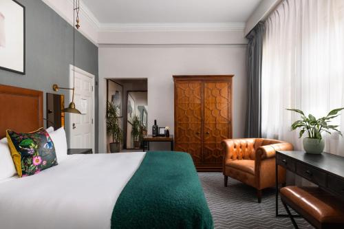 a bedroom with a bed and a desk and a chair at Kimpton Clocktower by IHG in Manchester