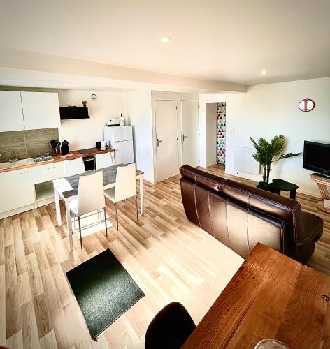 un salon avec une table et une cuisine dans l'établissement Chaleureux T2 meublé 5mn Alençon, à Cuissai