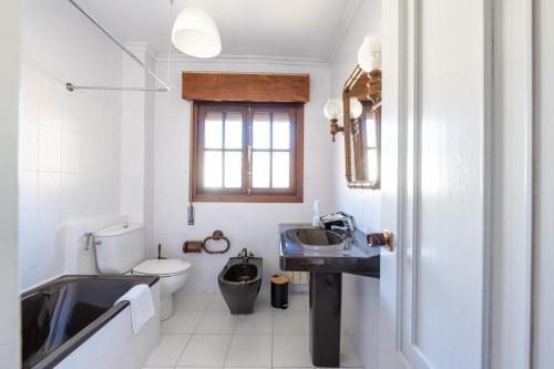 ein weißes Badezimmer mit Waschbecken und Toilette in der Unterkunft Casa Villa Maria in Canales