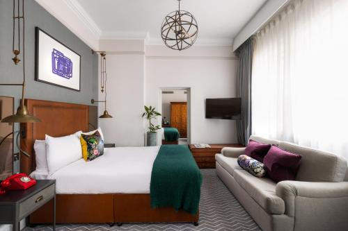 a hotel room with a bed and a couch at Kimpton Clocktower by IHG in Manchester