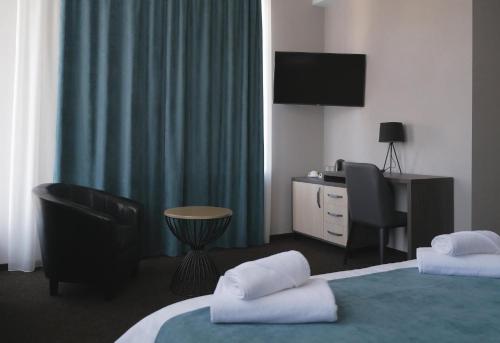a hotel room with a bed and a desk and a television at Urban Hotel EXPRESS in Ungheni