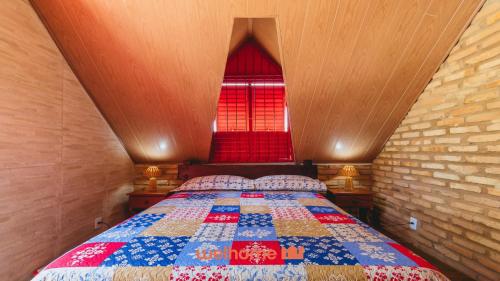 a bedroom with a bed with a red window at Casa charmosa a beira-mar em Paripueira - AL in Paripueira